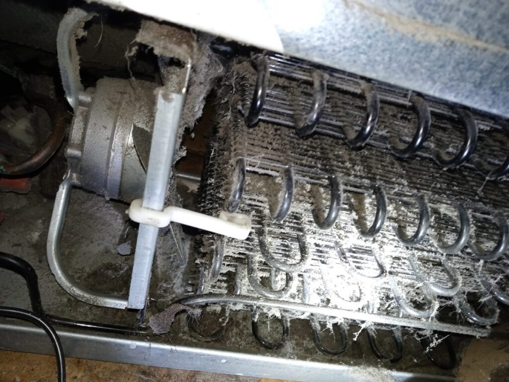 Refrigerator condenser coils packed with dust and lint, found during a repair call in Fayetteville NC